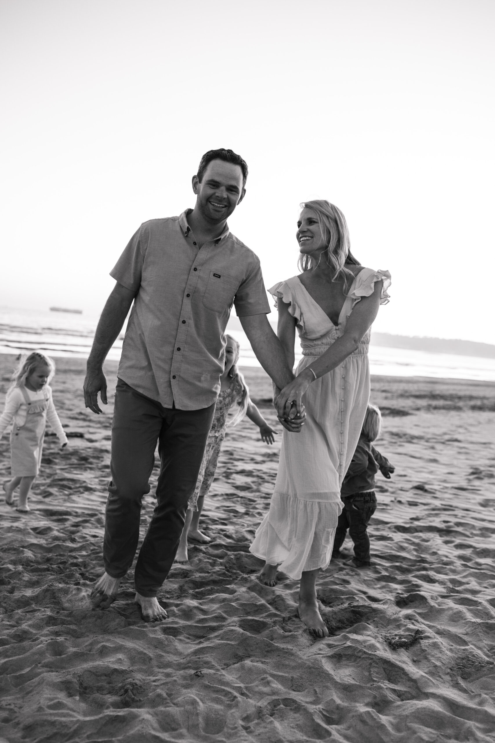 beach family photos sunset golden hour candid family photos family of four at sunset on the beach san Diego family photographer Sabrina kinsella sabrinalynnphoto